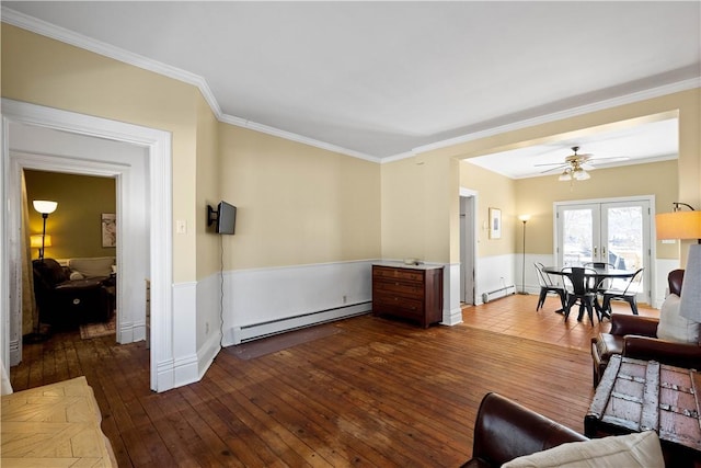 living room with ornamental molding, baseboard heating, and dark hardwood / wood-style flooring