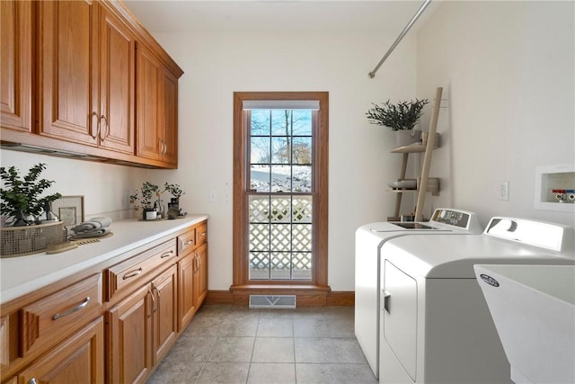 laundry room featuring light tile patterned flooring, sink, washing machine and clothes dryer, and cabinets