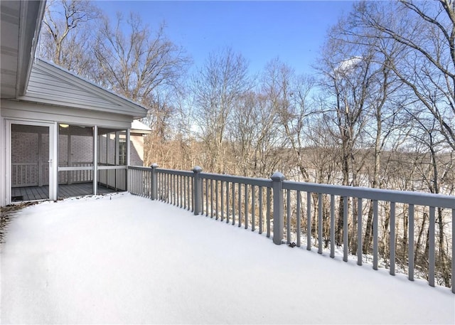 snow covered deck featuring a sunroom