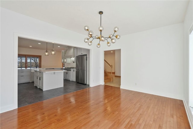 unfurnished living room featuring dark hardwood / wood-style flooring and an inviting chandelier