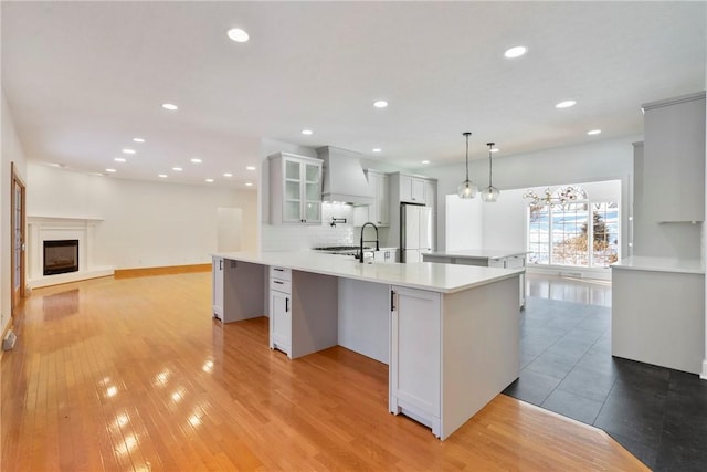 145 Cedar Rdg, Center Twp But, PA 16001 - kitchen with freestanding refrigerator, custom exhaust hood, light countertops, tasteful backsplash, and glass insert cabinets
