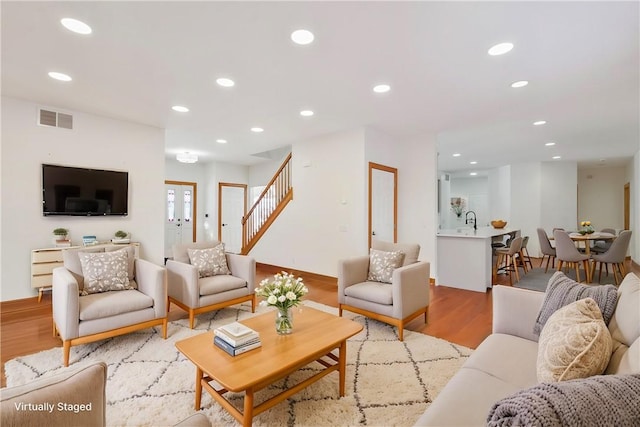 living room with sink and light wood-type flooring