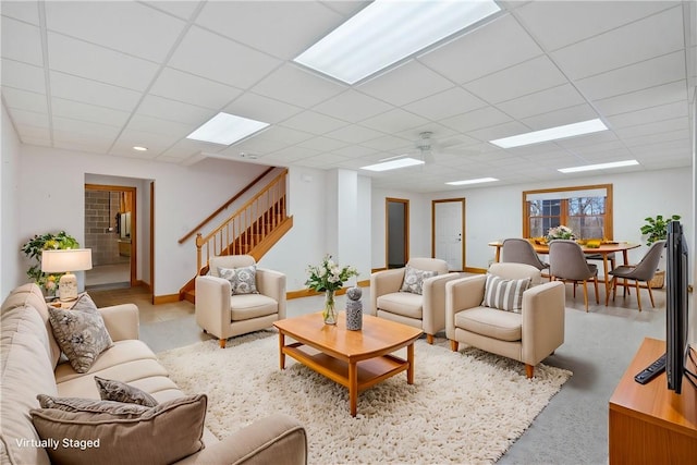 living room with a paneled ceiling and ceiling fan