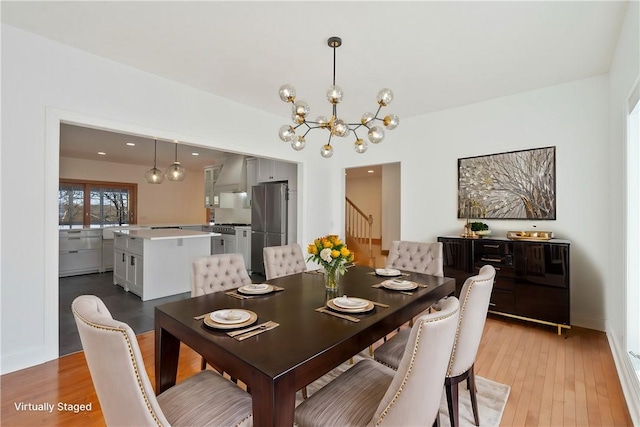 dining area featuring light wood-type flooring and a notable chandelier