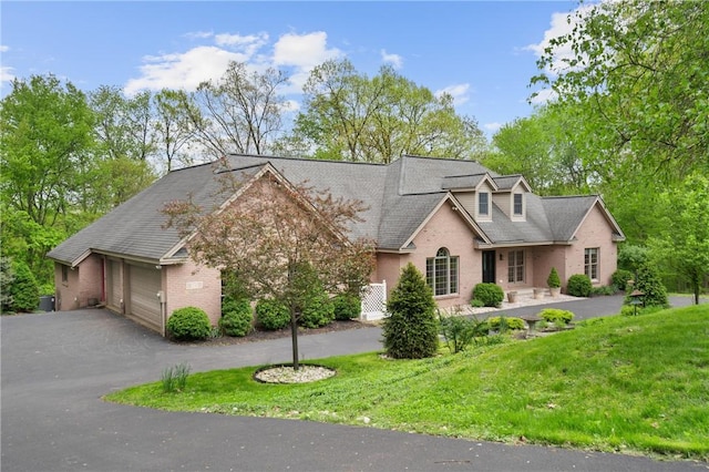 145 Cedar Rdg, Center Twp But, PA 16001 - cape cod house with brick siding, asphalt driveway, a front lawn, and a garage