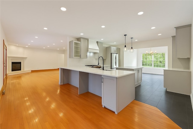 145 Cedar Rdg, Center Twp, PA 16001 - kitchen featuring gray cabinetry, custom exhaust hood, stainless steel fridge, light countertops, and wood finished floors