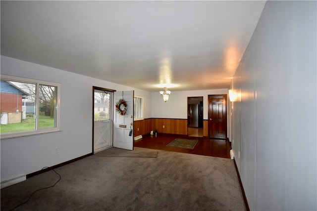 empty room featuring a notable chandelier and dark colored carpet