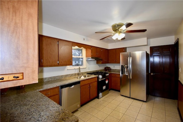 kitchen with dark stone counters, appliances with stainless steel finishes, ceiling fan, and sink