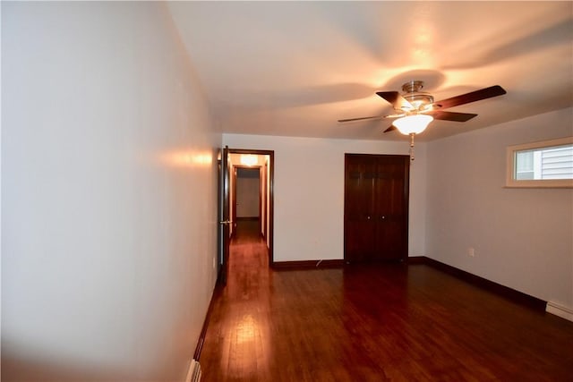 unfurnished bedroom with dark hardwood / wood-style flooring, a closet, and ceiling fan