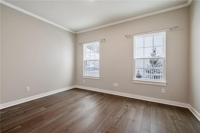 spare room featuring dark wood-type flooring and crown molding