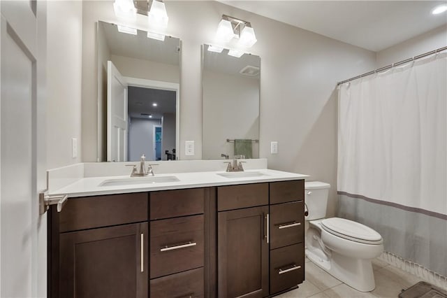 bathroom with toilet, vanity, tile patterned floors, and curtained shower