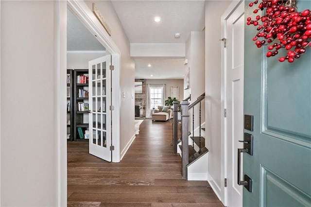 entryway with dark hardwood / wood-style flooring and a large fireplace