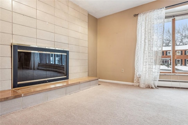 unfurnished living room with a tile fireplace and carpet floors