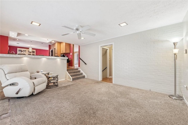 living room featuring brick wall, ceiling fan, and light carpet