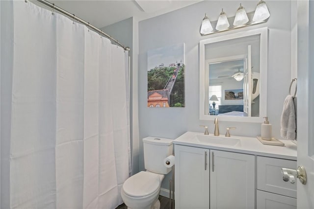 bathroom with toilet, curtained shower, ceiling fan, and vanity