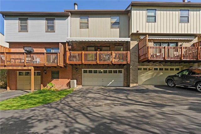 rear view of property featuring central AC and a garage