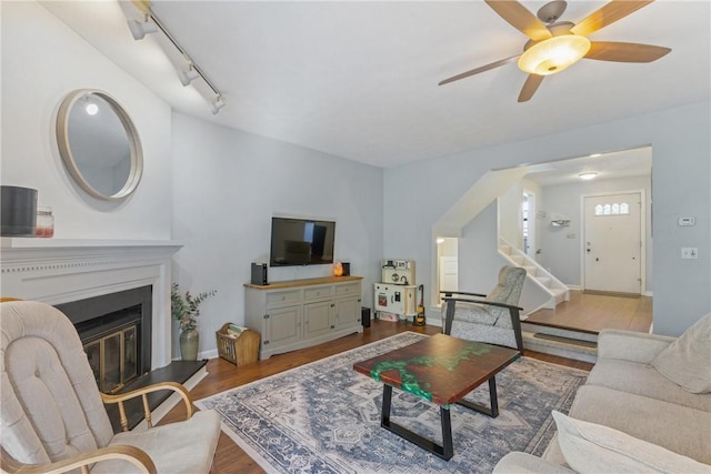 living room featuring light hardwood / wood-style floors, ceiling fan, and rail lighting