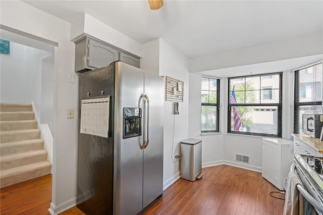 kitchen featuring appliances with stainless steel finishes, dark hardwood / wood-style flooring, gray cabinets, and ceiling fan