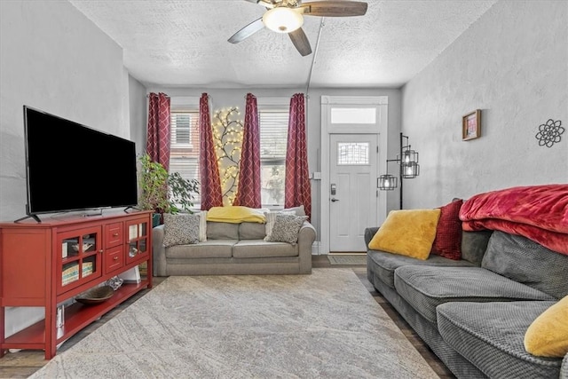 living room with a textured ceiling, ceiling fan, and hardwood / wood-style flooring