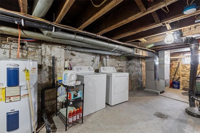 basement featuring washing machine and dryer, electric water heater, and heating unit