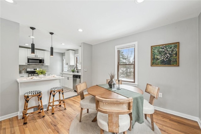 dining room featuring sink and light hardwood / wood-style flooring