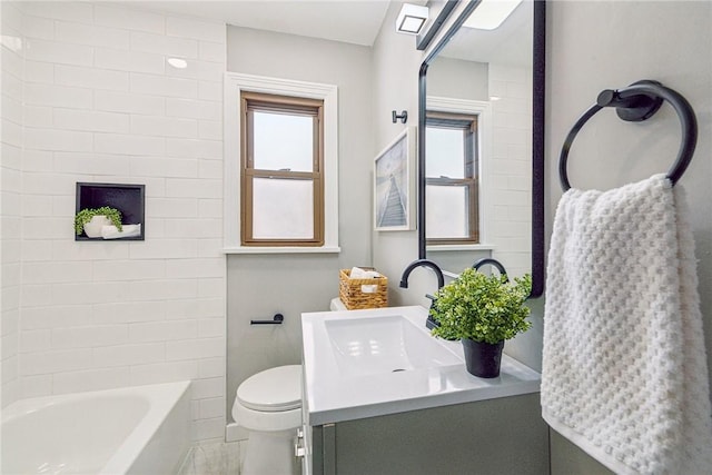 bathroom featuring a wealth of natural light, vanity, and toilet