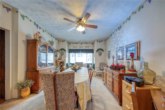 carpeted dining area with a textured ceiling and ceiling fan