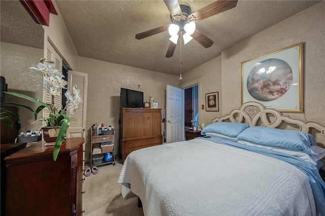 carpeted bedroom featuring a textured ceiling, a textured wall, and a ceiling fan