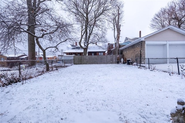 snowy yard with a garage