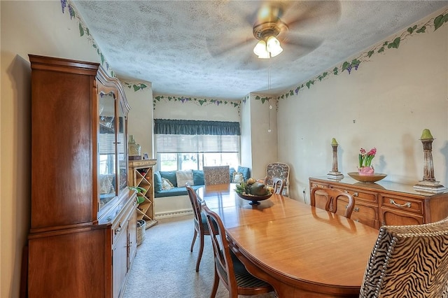 dining room with a ceiling fan, carpet flooring, a textured ceiling, and a baseboard heating unit