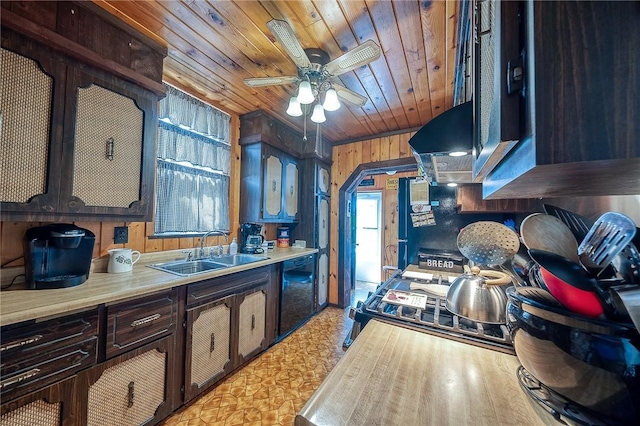 kitchen with light countertops, a sink, wood walls, and wooden ceiling