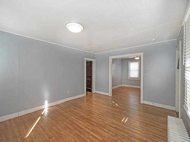 empty room featuring light wood-type flooring and radiator