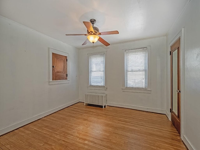 spare room featuring ceiling fan, radiator, and light hardwood / wood-style flooring