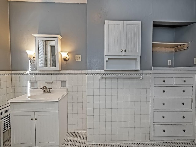 bathroom with tile walls, heating unit, and vanity