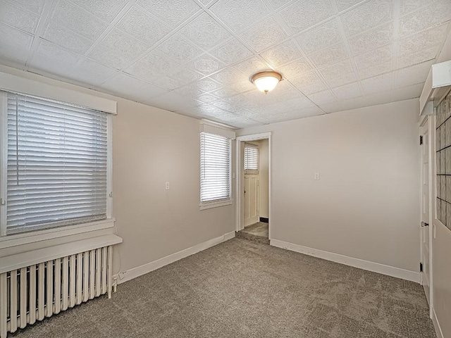 carpeted empty room with radiator heating unit