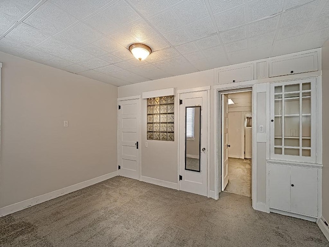 unfurnished room featuring a baseboard radiator and light carpet