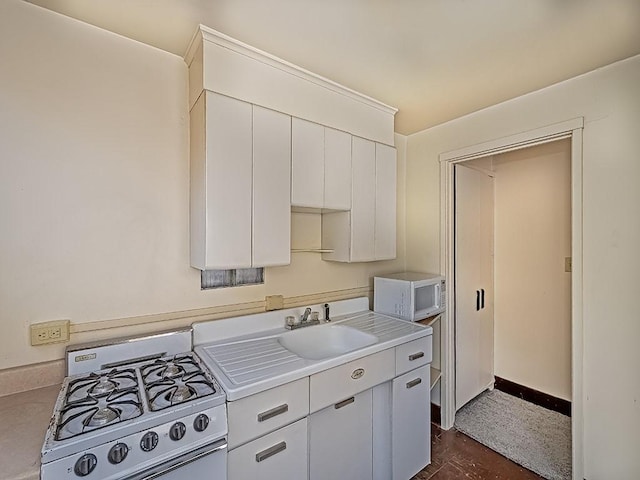 kitchen with white appliances, sink, dark hardwood / wood-style floors, and white cabinetry