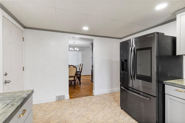 kitchen featuring a notable chandelier, stainless steel fridge with ice dispenser, crown molding, and white cabinetry