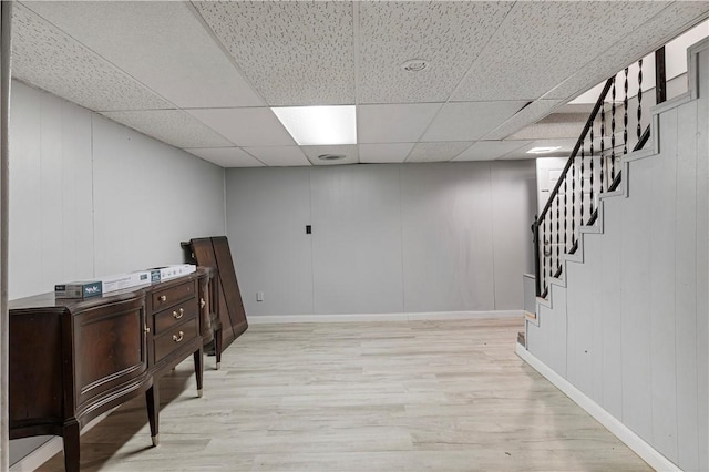 interior space featuring a paneled ceiling and light hardwood / wood-style flooring