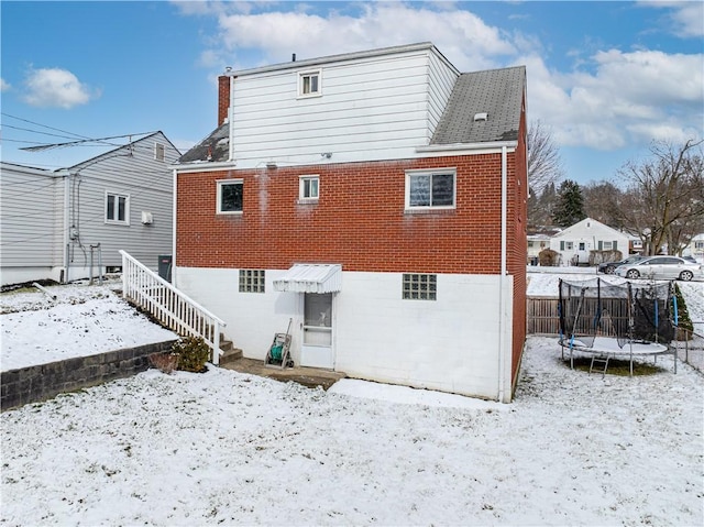 snow covered property featuring a trampoline