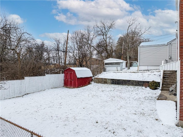 yard covered in snow with a shed