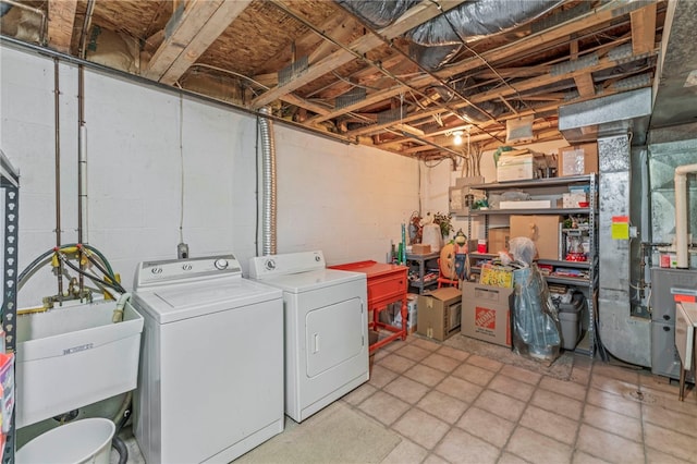 clothes washing area with washing machine and clothes dryer and sink