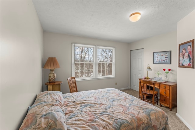 bedroom featuring a textured ceiling, a closet, and light carpet