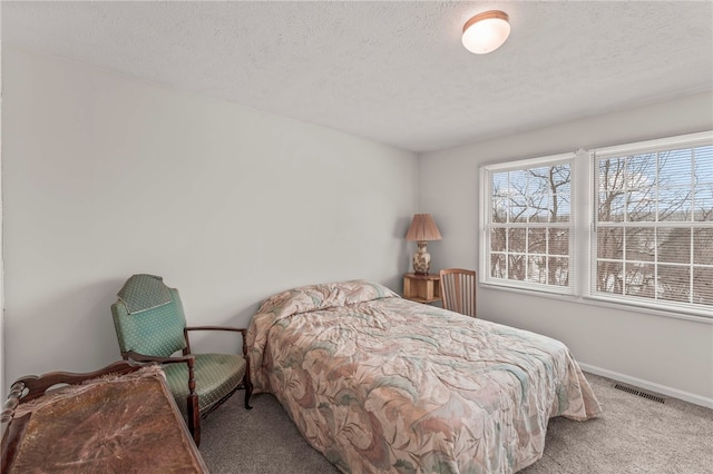 bedroom featuring a textured ceiling and light carpet