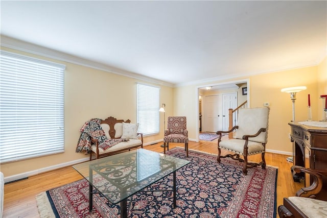 living room with light wood-type flooring and ornamental molding