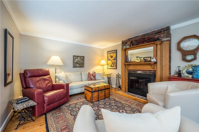 living room featuring a fireplace, light hardwood / wood-style floors, and crown molding