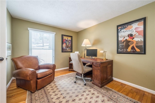 office space featuring a textured ceiling and light hardwood / wood-style flooring