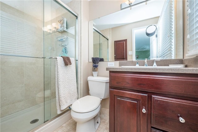 bathroom with toilet, a shower with shower door, and vanity