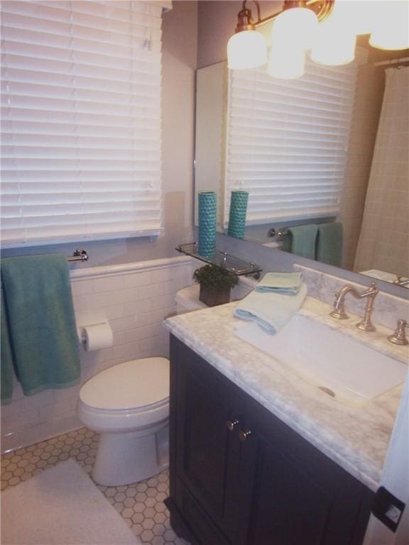 bathroom featuring tile walls, toilet, tile patterned floors, and vanity