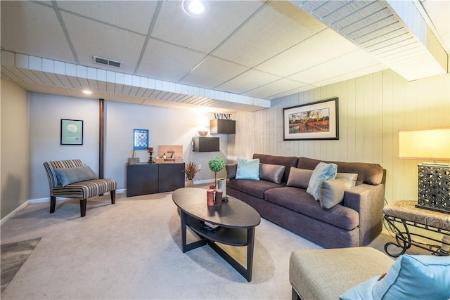 living room featuring a paneled ceiling and carpet